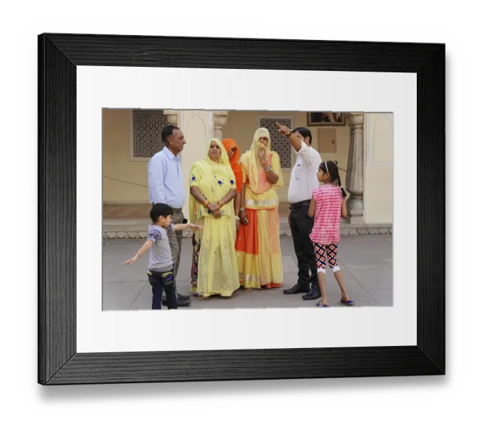 Framed Print : Family group in colourful traditional clothing during a conversation in the courtyard