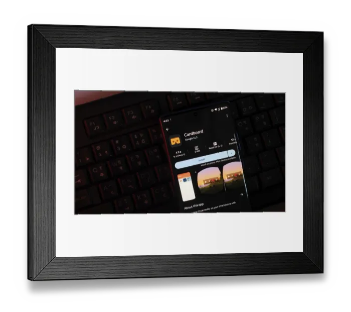 Framed Print : Smartphone displaying Cardboard app interface in dark lighting over a keyboard