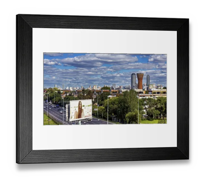 Framed Print : Cityscape with skyscrapers, a large billboard and busy traffic under a cloudy sky Framed Print : Cityscape with skyscrapers, a large billboard and busy traffic under a cloudy sky