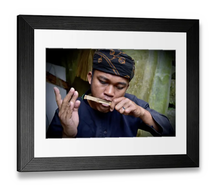 Framed Print : A musician concentrates on playing a traditional bamboo instrument