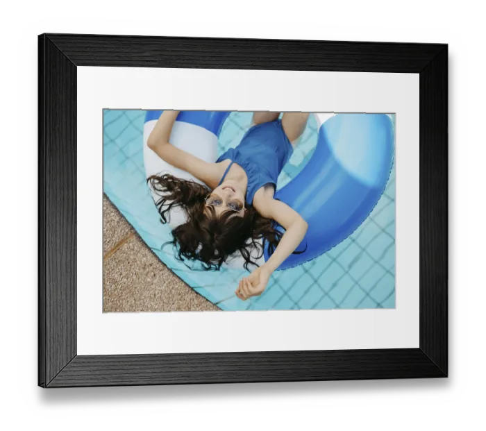 Framed Print : Girl, 10, swims in a swimming tyre in the pool