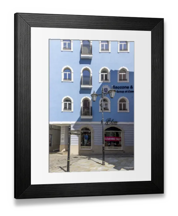 Framed Print : Typical building with rounded windows on a blue facade and characteristic street lamp in the old town