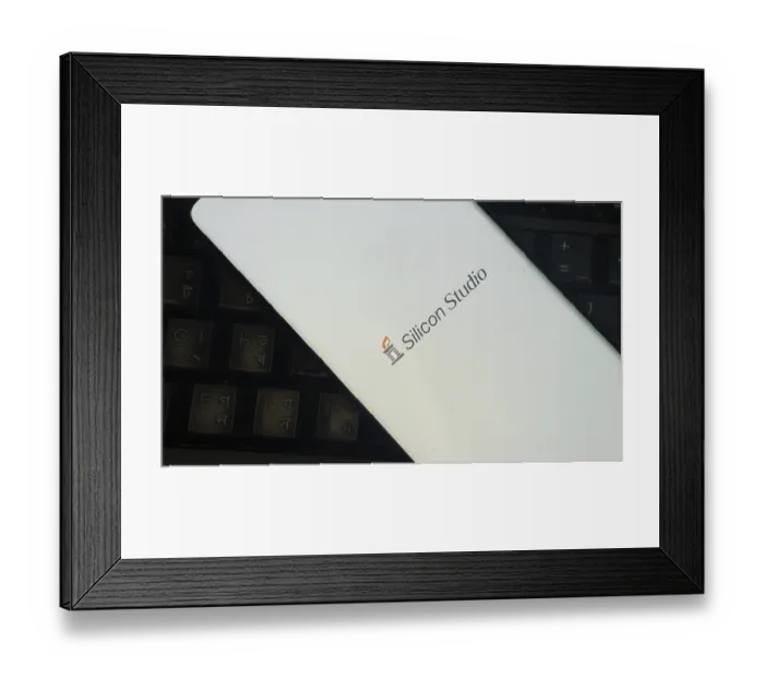 Framed Print : Silicon Studio logo on smartphone placed on a keyboard