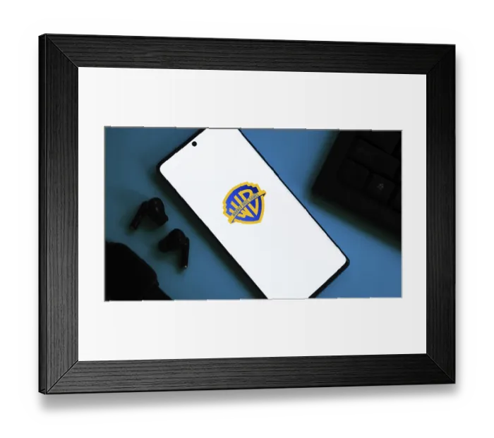 Framed Print : Smartphone showing Warner Bros logo with earphones on a blue background Framed Print : Smartphone showing Warner Bros logo with earphones on a blue background