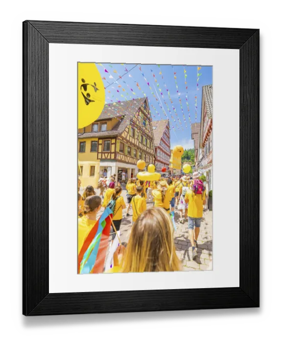 Framed Print : People in yellow clothes walk under colourful pennants in a narrow street in front of traditional houses Framed Print : People in yellow clothes walk under colourful pennants in a narrow street in front of traditional houses