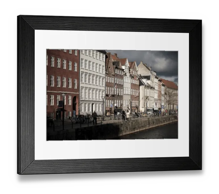 Framed Print : Sunlit row of historic buildings along a canal in a European city