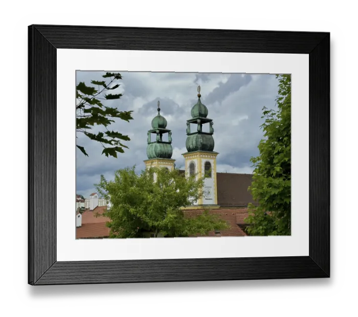 Framed Print : Two striking steeples rise above the trees against a dramatic sky