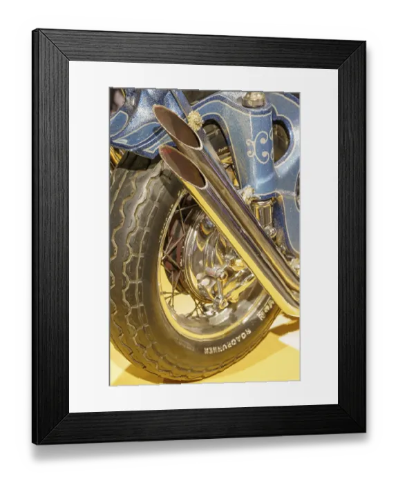 Framed Print : Decorated blue motorbike exhaust with tyres on a yellow base