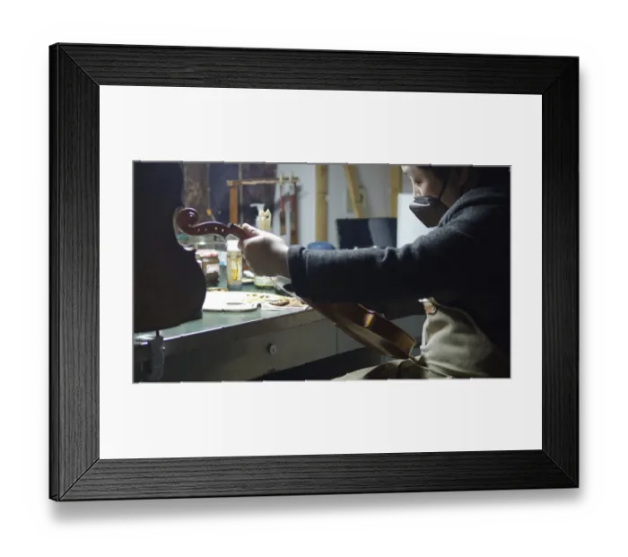 Framed Print : A luthier meticulously working on a violin in a well-equipped workshop Framed Print : A luthier meticulously working on a violin in a well-equipped workshop