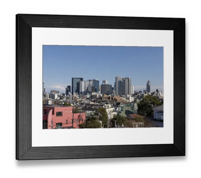 Framed Print : Modern architecture, view over the rooftops of the city to the glass facades of skyscrapers against a blue sky