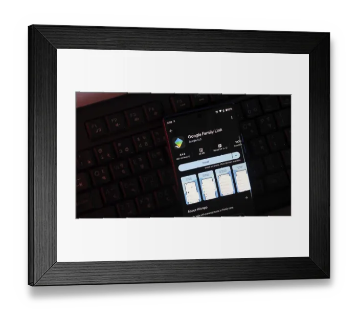 Framed Print : Google Family Link app page shown on a smartphone screen in dark mode with a keyboard background Framed Print : Google Family Link app page shown on a smartphone screen in dark mode with a keyboard background