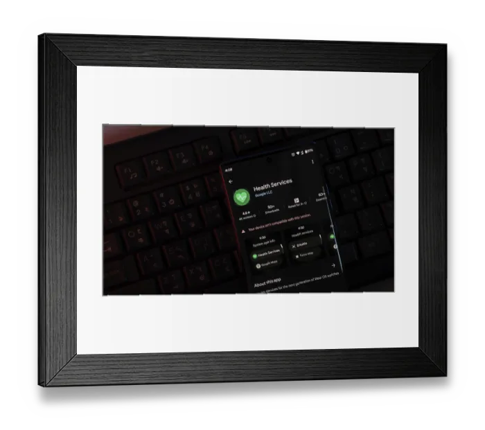 Framed Print : Smartphone displaying Health Services app interface in a dark setting with visible keyboard