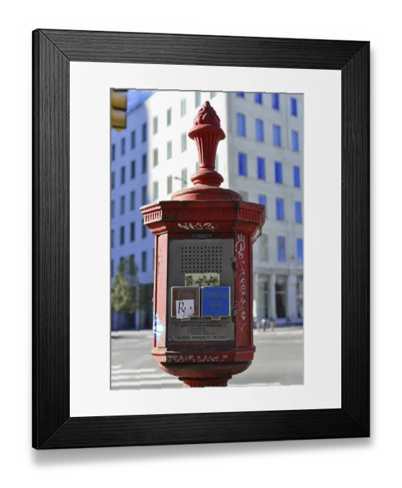 Framed Print : Red emergency call pillar in an urban environment with historical flair