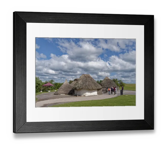 Framed Print : Tourists visit the replicas of Neolithic houses at the Stonehenge visitor centre