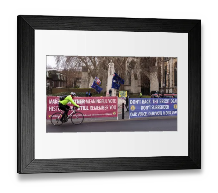 Framed Print : Cyclist rides by an anti-Brexit protest with colorful banners and flags in the City of Westminster