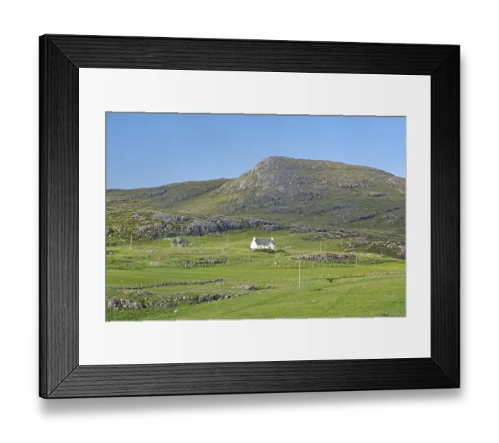 Framed Print : Small house in a green valley surrounded by mountains under clear skies Framed Print : Small house in a green valley surrounded by mountains under clear skies