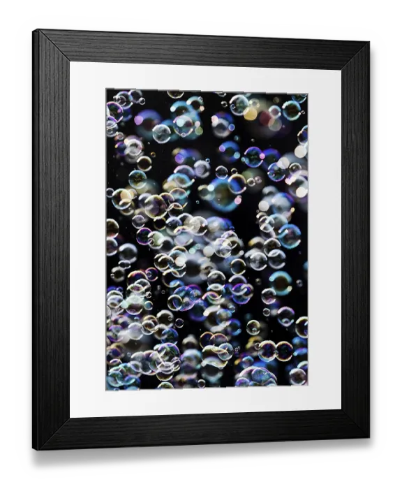Framed Print : Many, small iridescent and floating soap bubbles against a black background