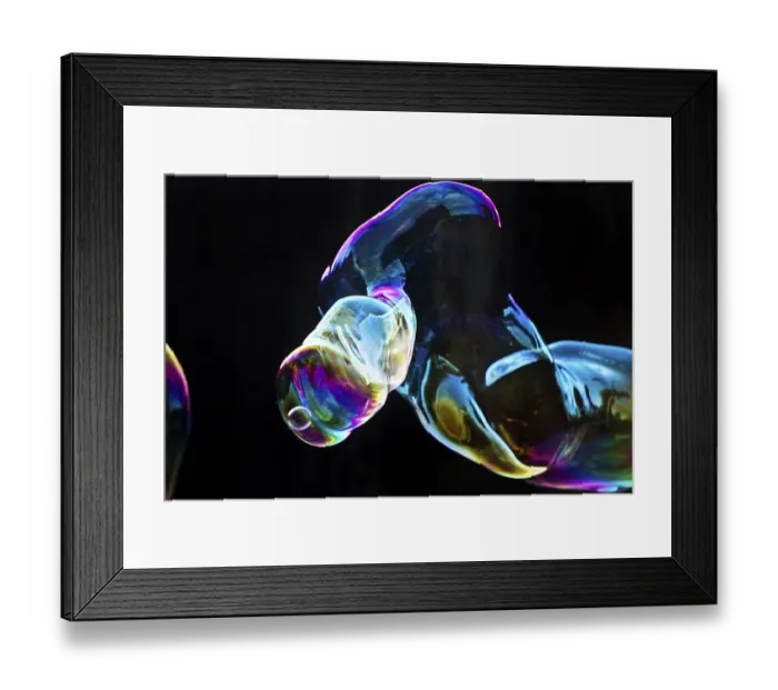 Framed Print : Large, iridescent soap bubble tube in the colours of the rainbow against a black background Framed Print : Large, iridescent soap bubble tube in the colours of the rainbow against a black background