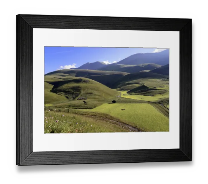 Framed Print : Green, hilly landscape under a clear blue sky