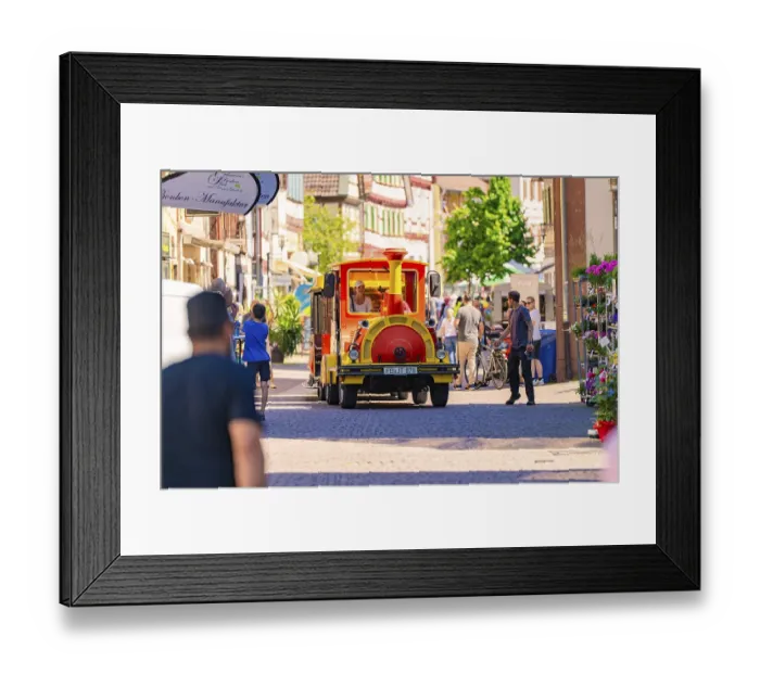 Framed Print : Tourist train travelling through busy city street in the sunshine