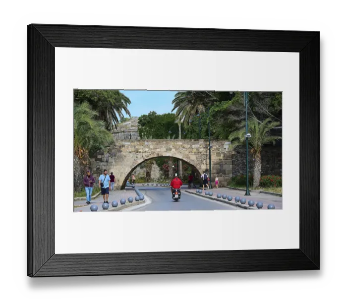 Framed Print : Street scene with arched bridge and people under palm trees along the road Framed Print : Street scene with arched bridge and people under palm trees along the road