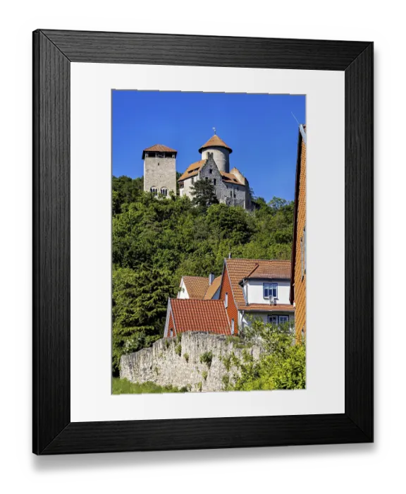Framed Print : Half-timbered houses with red roofs in front of a castle on a wooded hill
