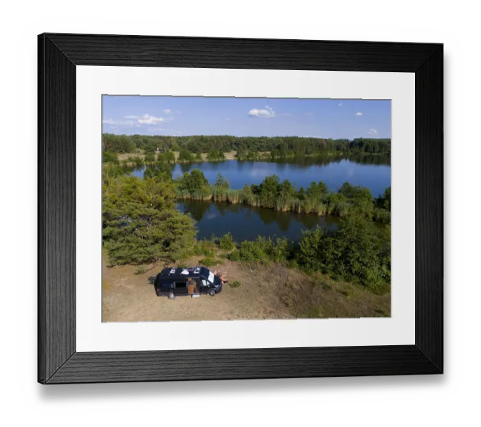 Framed Print : A van stands by a forest lake, surrounded by lush greenery and a blue sky Framed Print : A van stands by a forest lake, surrounded by lush greenery and a blue sky
