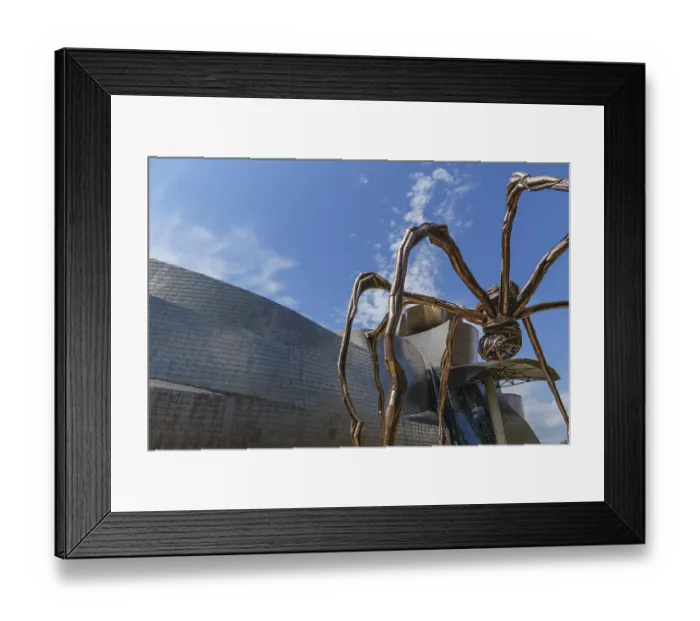Framed Print : A spider sculpture in front of a modern building with a reflective facade