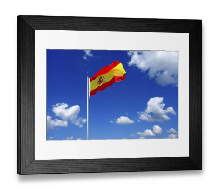 Framed Print : The flag of Spain flutters in the wind in a blue sky with white clouds