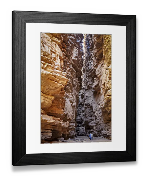 Framed Print : Deep, narrow gorge with dramatic incidence of light and a person surrounded by rocky walls