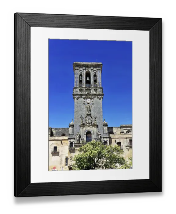 Framed Print : High stone tower with decorative reliefs and blue sky in the background
