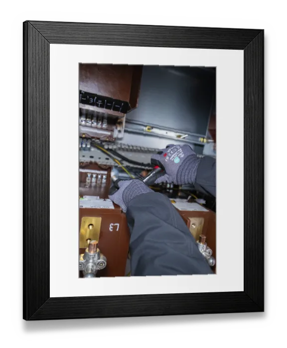 Framed Print : A technician uses tools for maintenance work inside a switch box Framed Print : A technician uses tools for maintenance work inside a switch box
