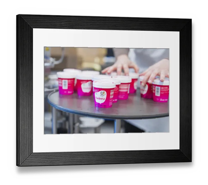 Framed Print : Small pink ice-cream tubs stand on a table Framed Print : Small pink ice-cream tubs stand on a table