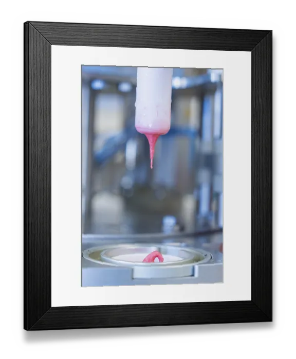 Framed Print : Pink liquid ice cream drips from a machine into a container Framed Print : Pink liquid ice cream drips from a machine into a container