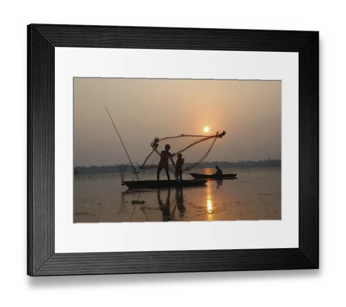Framed Print : Fishermen in boat throwing net in silhouette
