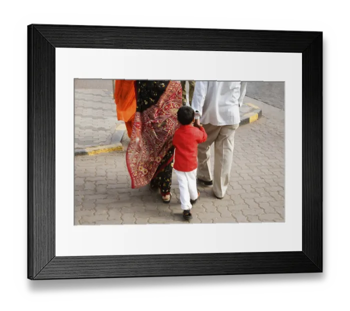 Framed Print : Indian Boy wearing red color shirt following the parents