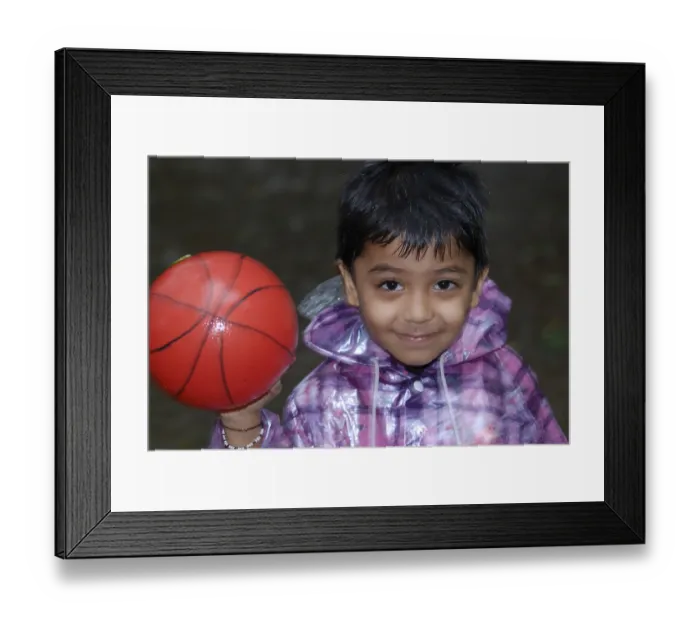 Framed Print : Child Playing in the Rain with ball, India