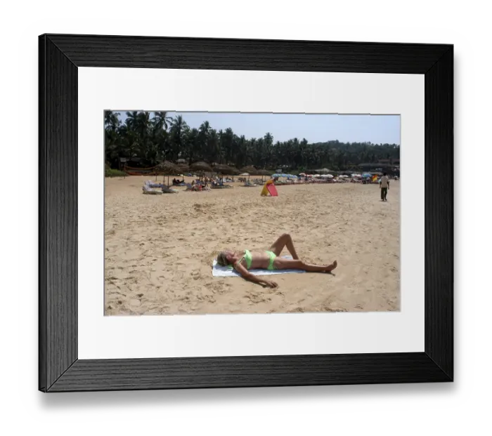 Framed Print : A foreign tourist enjoying sun bath on the Sinquerim beach of Goa