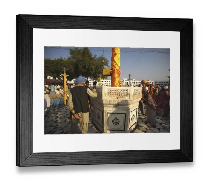 Framed Print : Sikh devotee paying his respect to Nishansahib compound of Sachkhand Saheb Gurudwara