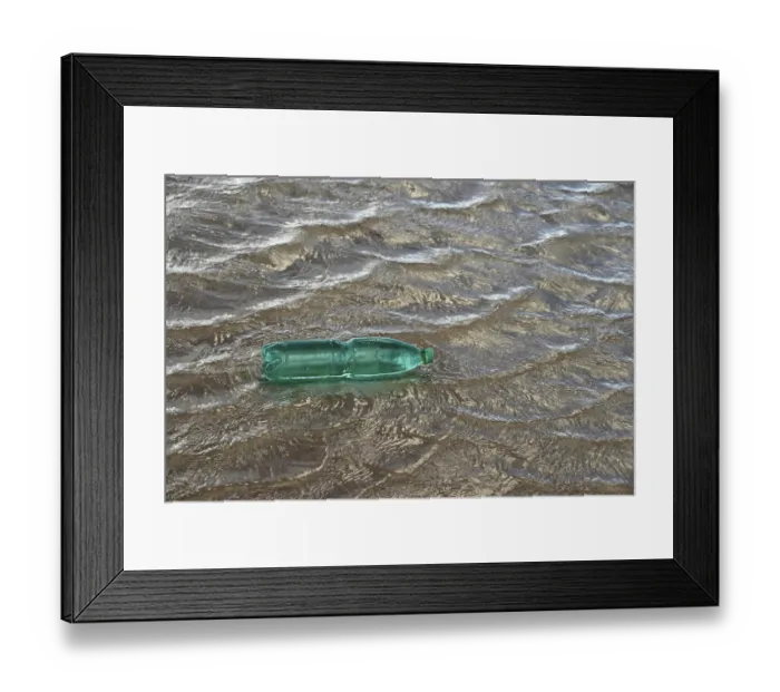 Framed Print : Pollution theme with a green plastic bottle floating on water surface Framed Print : Pollution theme with a green plastic bottle floating on water surface