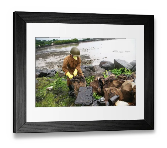 Framed Print : Volunteer cleaning oil spill garbage at elephanta island