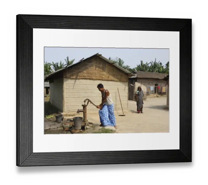 Framed Print : Man using hand pump in village, Assam, India NOMR