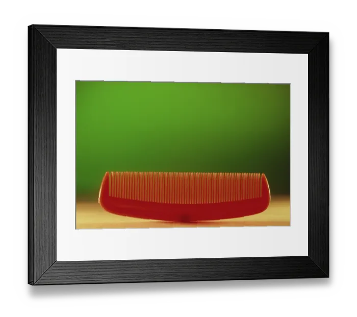 Framed Print : Concept, plastic comb against green background