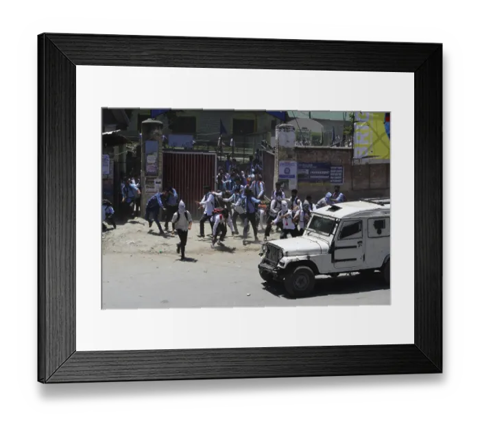 Framed Print : Kashmiri students protest by stone pelting at police jeep