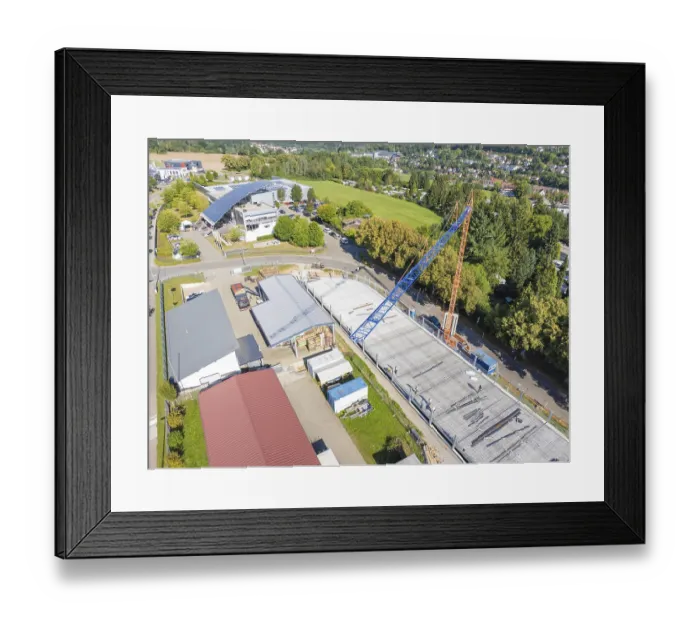 Framed Print : Construction site under blue sky with crane in urban environment and many trees