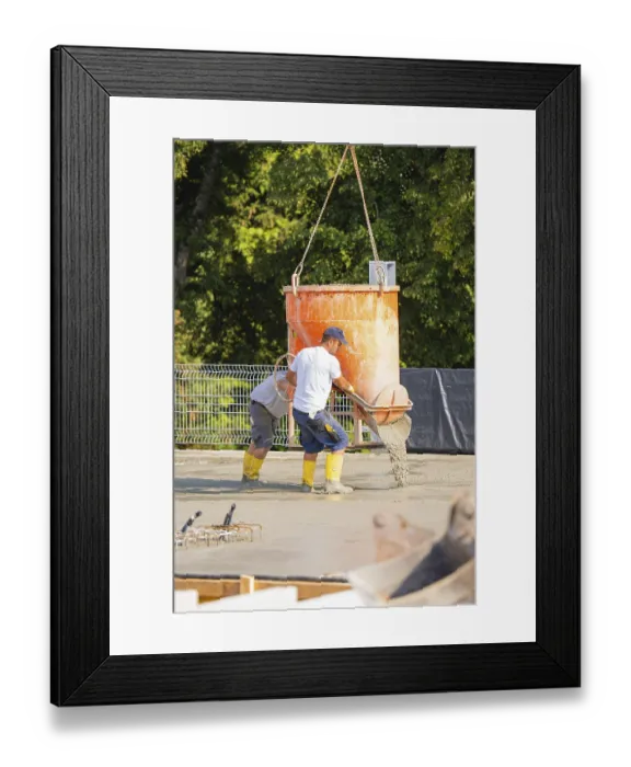 Framed Print : Two construction workers pouring concrete from a concrete mixer on a building site Framed Print : Two construction workers pouring concrete from a concrete mixer on a building site