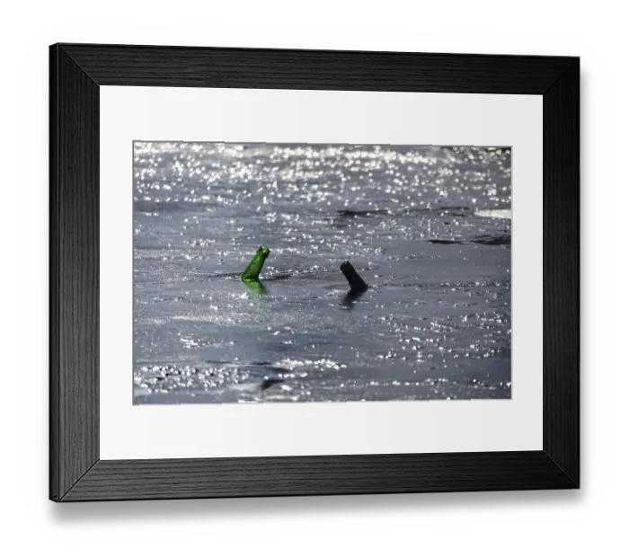 Framed Print : Discarded glass bottles in a frozen lake