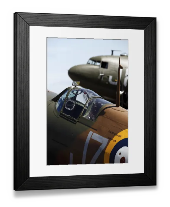 Framed Print : A vintage Spitfire fighter plane pictured in front of a DC-3 transport aircraft from World War Two at the Cotswold