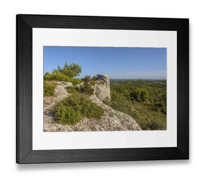 Framed Print : A rocky hill with a view of a town in the distance Framed Print : A rocky hill with a view of a town in the distance
