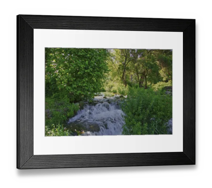 Framed Print : A small waterfall flows through a green